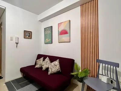 a living room with a red couch and a table at MOA - Walking Distance to Mall Cheap Accommodation in Manila
