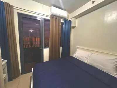 a bedroom with a bed and a large window at MOA - Pasay Cheap Accommodation in Manila