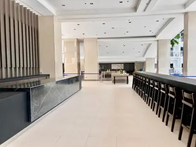 an empty lobby with a long hallway with tables and chairs at MOA - Pasay Cheap Accommodation in Manila