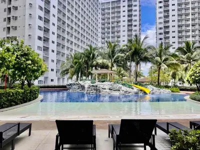 a large swimming pool with two chairs and a fountain at MOA - Aseana Value for Money Super Cozy Condo in Manila