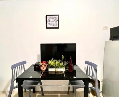 a dining room table with two chairs and a tv at Mall of Asia Shore Residence - Perfect Location in Manila