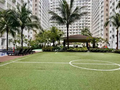 a basketball court in front of a building with palm trees at Mall of Asia Shore Residence - Perfect Location in Manila