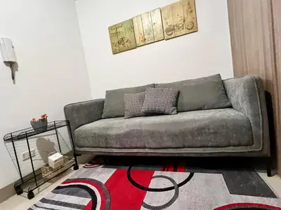 a living room with a couch and a rug at Mall of Asia Shore Residence - Perfect Location in Manila