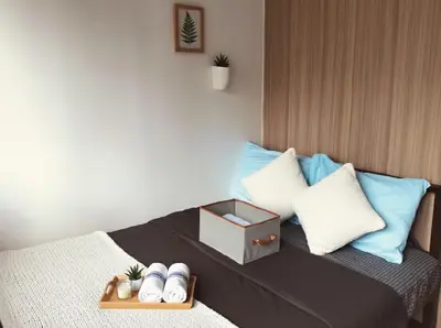 a bed with pillows and a tray with a box on it at Mall Of Asia - Aseana Super Value for Money in Manila