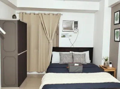 a bedroom with a bed with a blue comforter at Mall of Asia - Aseana - Walking Distance to Mall in Manila