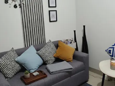 a living room with a gray couch with pillows at Mall of Asia - Aseana - Walking Distance to Mall in Manila