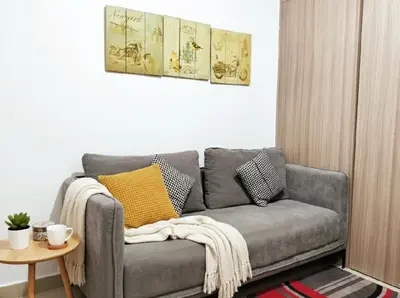 a grey couch in a living room with a table at Value for Money Mall of Asia - Aseana City Center in Manila