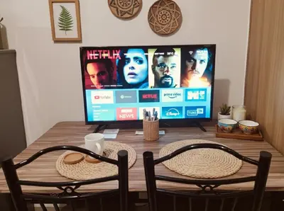 a television sitting on top of a wooden table with two chairs at Value for Money Mall of Asia - Aseana City Center in Manila