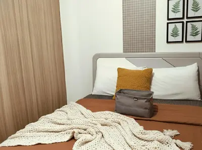 a bed with a blanket and a bag on it at Value for Money Mall of Asia - Aseana City Center in Manila