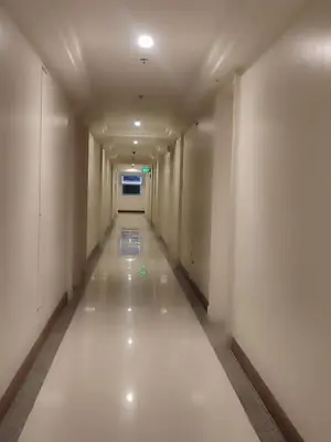 an empty corridor with white walls and a long hallway at BP952 With Balcony and River View in Manila
