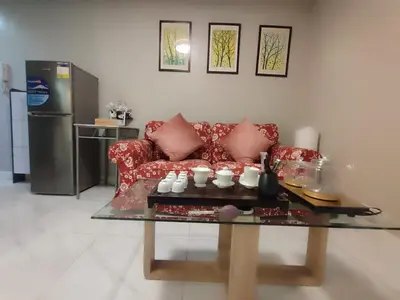 a living room with a red couch and a glass table at BP952 With Balcony and River View in Manila