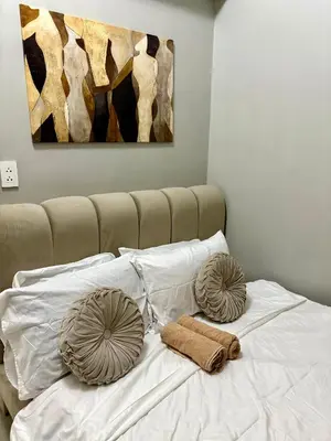 a bed with two pillows on top of it at Stylish Comfy and Cozy in Manila