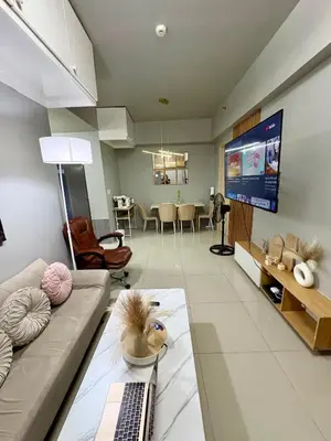 a living room with a couch and a flat screen tv at Stylish Comfy and Cozy in Manila