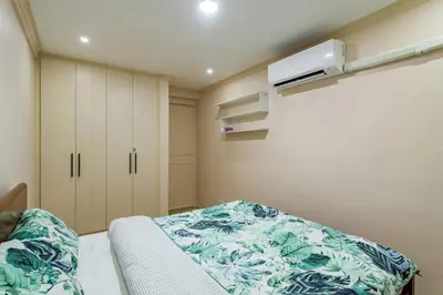 a small bedroom with a bed and a air conditioner at Modern 4BR House with Billiards,KTV,WIFI,Netflix-10mins from Robinson Mall in Manila