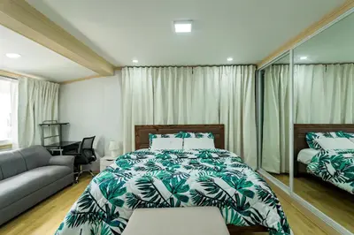 a bedroom with a bed and a couch at Modern 4BR House with Billiards,KTV,WIFI,Netflix-10mins from Robinson Mall in Manila