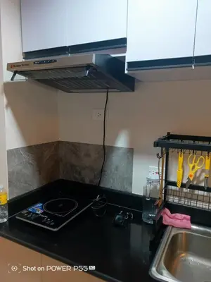 a kitchen with a stove top oven next to a sink at SMDC Field REsidences condo unit in Manila
