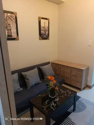 a living room with a blue couch and a table at SMDC Field REsidences condo unit in Manila