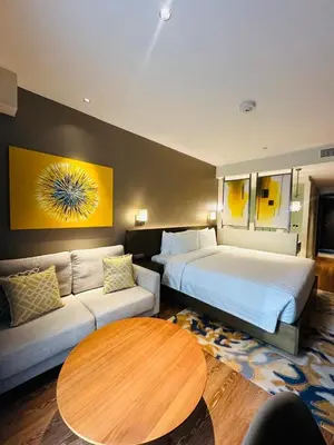 a hotel room with two beds and a couch at Novotel Suites Residences Mandaluyong-Makati by Marj in Manila