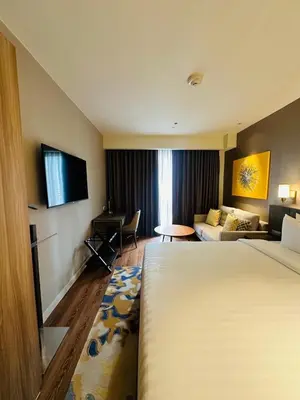 a hotel room with a bed and a couch at Novotel Suites Residences Mandaluyong-Makati by Marj in Manila