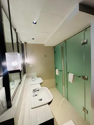 a bathroom with two sinks and a shower at Novotel Suites Residences Mandaluyong-Makati by Marj in Manila