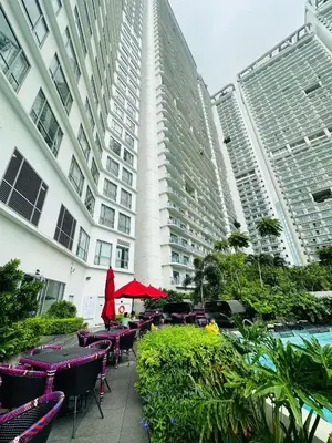 a patio with tables and chairs in front of a building at Novotel Suites Residences Mandaluyong-Makati by Marj in Manila