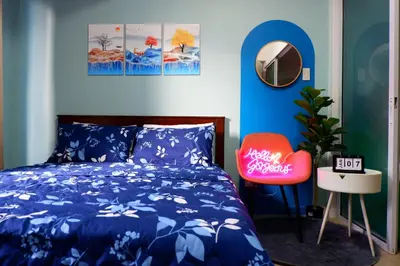 a bedroom with a blue bed and a red chair at Azure Staycation By Star in Manila