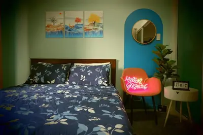 a bedroom with a bed and a chair and a mirror at Azure Staycation By Star in Manila