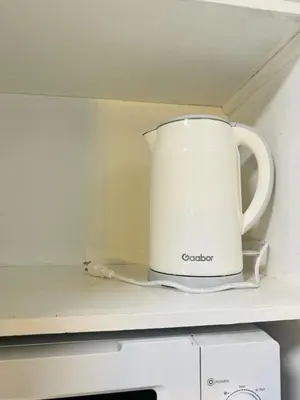 a white coffee pot sitting on top of a microwave at 2BR condo unit near BGC in Manila