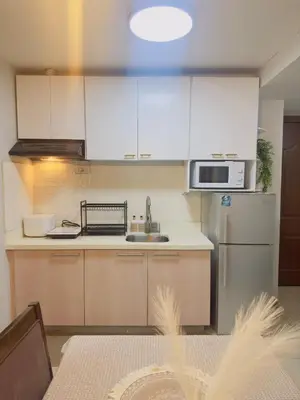 a kitchen with white cabinets and a stainless steel refrigerator at 2BR condo unit near BGC in Manila