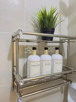 a bathroom shelf with four bottles of shampoo at 2BR condo unit near BGC in Manila