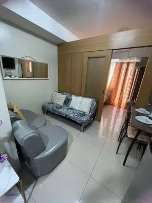 a living room with a couch and a table at 1441-Pool view 1BR 1 sofa Bed 1 Extra mattress in Manila