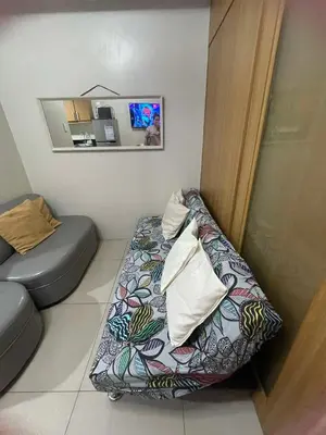 a small room with a couch and a mirror at 1441-Pool view 1BR 1 sofa Bed 1 Extra mattress in Manila