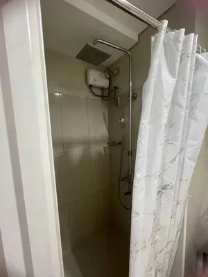 a shower with a shower curtain in a bathroom at 1441-Pool view 1BR 1 sofa Bed 1 Extra mattress in Manila