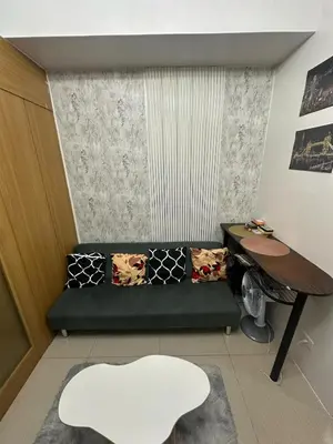 a living room with a couch and a table at Shell Residences pool view in Manila