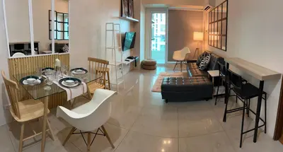 a living room with a glass table and chairs at Beacon Makati Skyline View in Manila