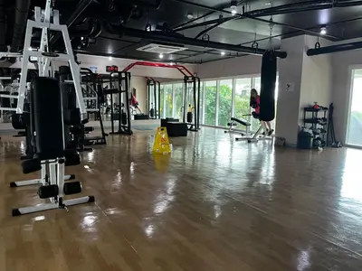 a gym with a wooden floor and a woman in the background at Beacon Makati Skyline View in Manila