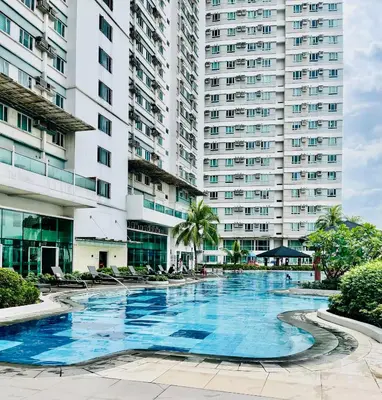 a large swimming pool in front of a large building at Beacon Makati Skyline View in Manila