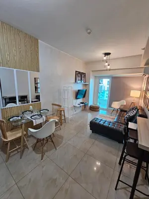 a living room with a couch and a table and chairs at Beacon Makati Skyline View in Manila