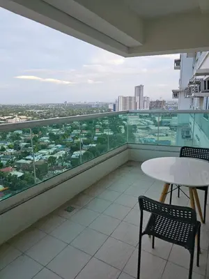 a balcony with a table and chairs and a view at Beacon Makati Skyline View in Manila
