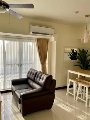 a living room with a leather couch and a table at 5 Star Luxury Condo - Metro Manila in Manila