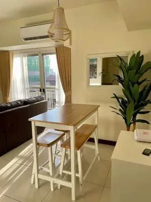 a dining room table and chairs in a living room at 5 Star Luxury Condo - Metro Manila in Manila