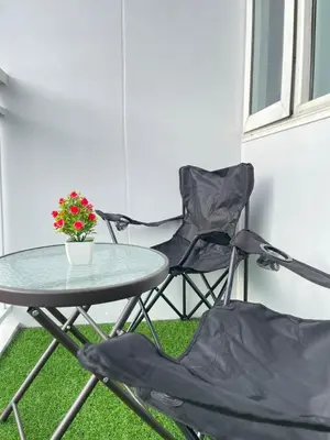 a table and two chairs and a table with flowers at Dandelion Shore Residences 1BR in Manila