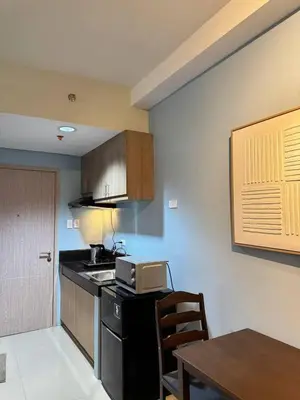 a kitchen with a stove and a table in it at D&M cosy staycation in Manila