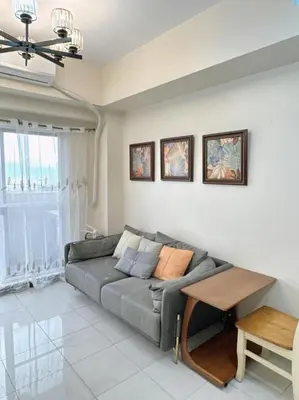 a living room with a couch and a table at Scenic place to stay in manila 3618 in Manila
