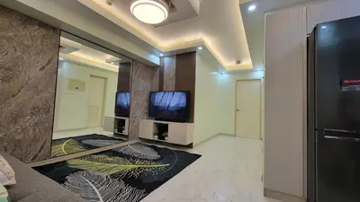 a room with two televisions and a large mirror at Levina Place 2BR Resort inspired in Manila