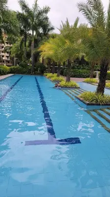 a large swimming pool with palm trees in a resort at Levina Place 2BR Resort inspired in Manila