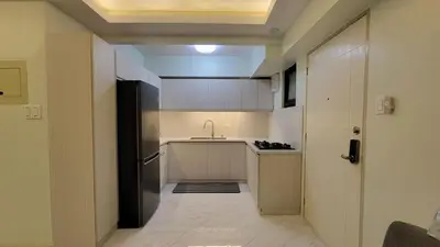 a small kitchen with a sink and a refrigerator at Levina Place 2BR Resort inspired in Manila