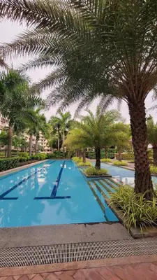 a large swimming pool with palm trees in a resort at Levina Place 2BR Resort inspired in Manila