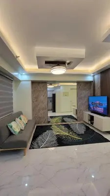 a living room with a couch and a flat screen tv at Levina Place 2BR Resort inspired in Manila