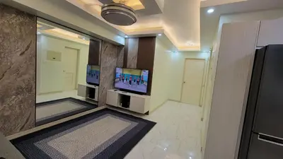 a room with two televisions on a wall with a tv at Levina Place 2BR Resort inspired in Manila